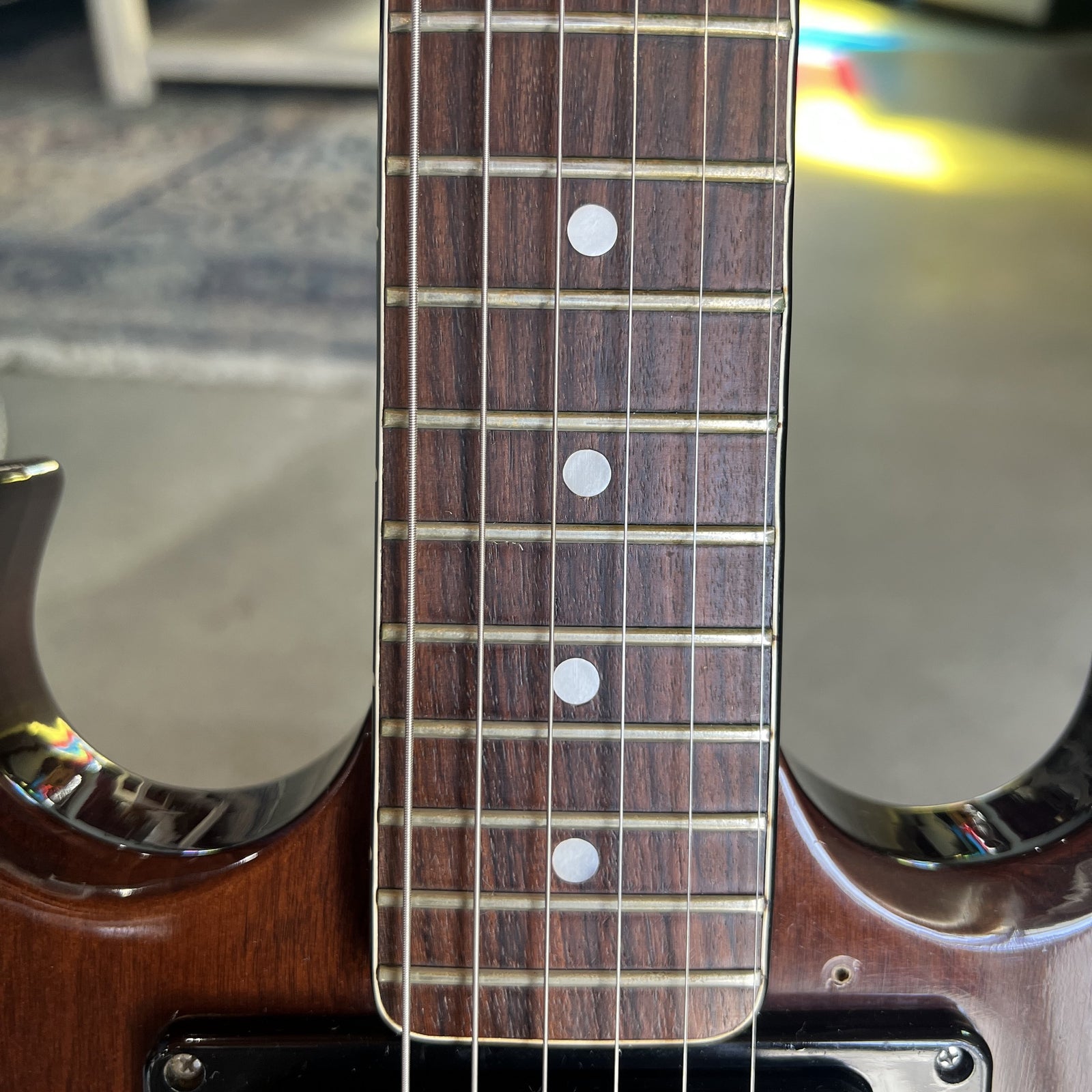 Close-up of the rosewood fretboard featuring pearloid dot inlays and vintage fret wire