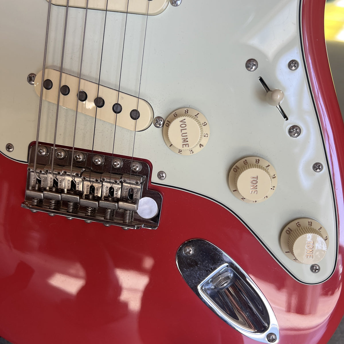 Close up of the Fiesta Red alder body, mint green pickguard, and pure vintage pickups on the 1961 Stratocaster