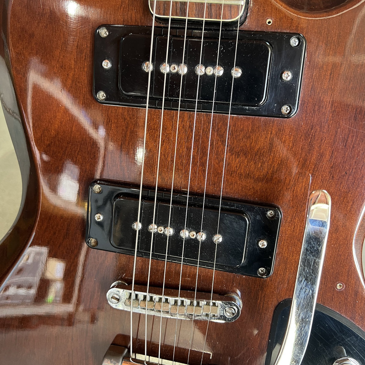 Close-up view of the dual P-90 style single-coil pickups and adjustable roller br